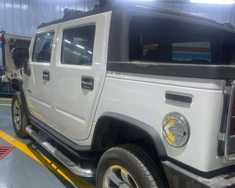 A Sial Kingdom technician performing an engine oil and general service on a Hummer H2 at the Al Maabilah workshop.