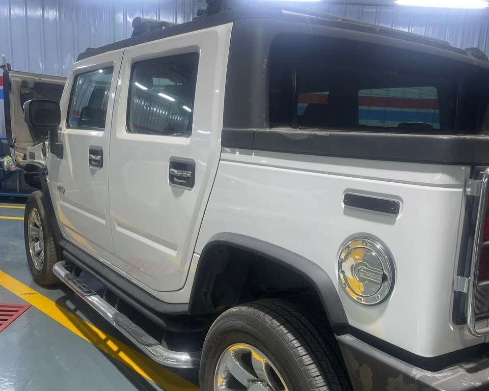 A Sial Kingdom technician performing an engine oil and general service on a Hummer H2 at the Al Maabilah workshop.