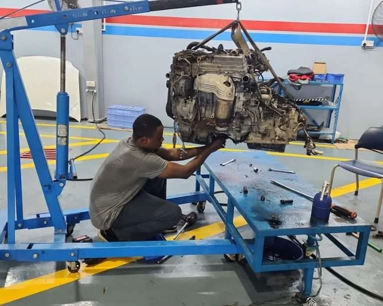 A Sial Kingdom technician using a diagnostic scanner to check a vehicle's ABS and brake system in Muscat.