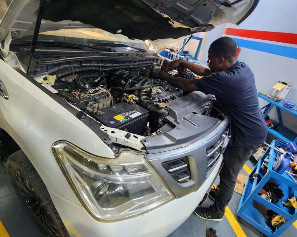 A Sial Kingdom technician working on a car engine at the Al Maabilah workshop in Muscat.