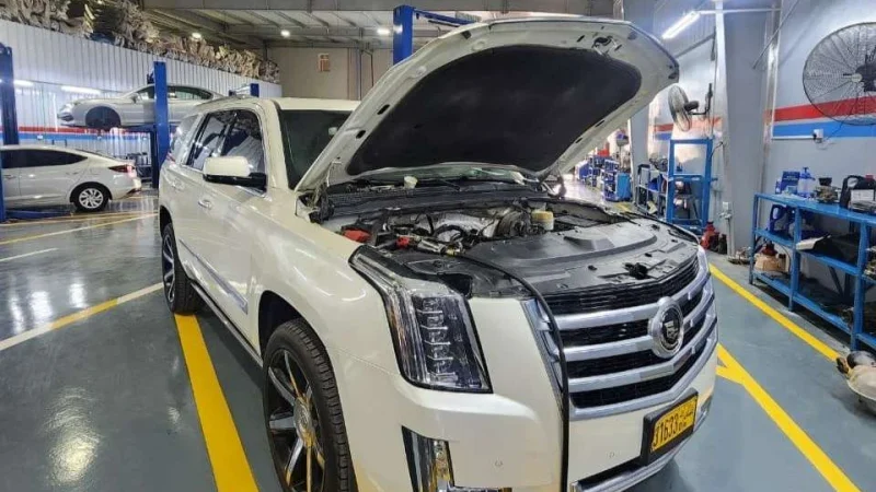 فني سيال كينغدوم يعمل على محرك سيارة كاديلاك إسكاليد في ورشة المعبيلة الصناعية بمسقط