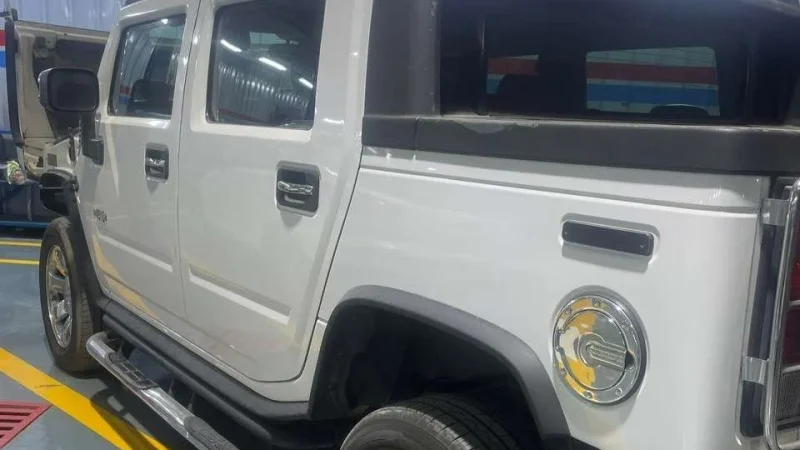 A Sial Kingdom technician performing an engine oil and general service on a Hummer H2 at the Al Maabilah workshop.