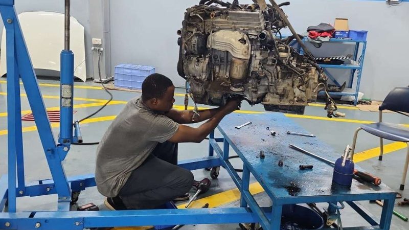 A Sial Kingdom technician using a diagnostic scanner to check a vehicle's ABS and brake system in Muscat.