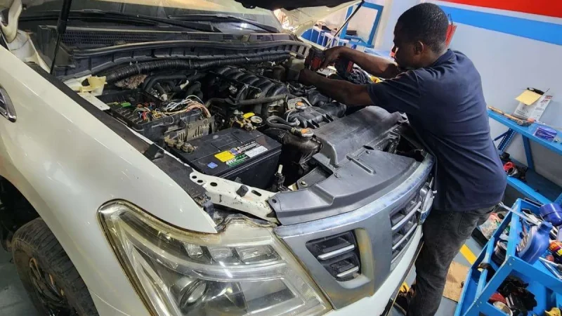 A Sial Kingdom technician working on a car engine at the Al Maabilah workshop in Muscat.