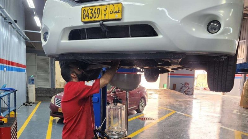 A Sial Kingdom technician inspecting the underbody of a vehicle at the Al Maabilah workshop in Muscat.